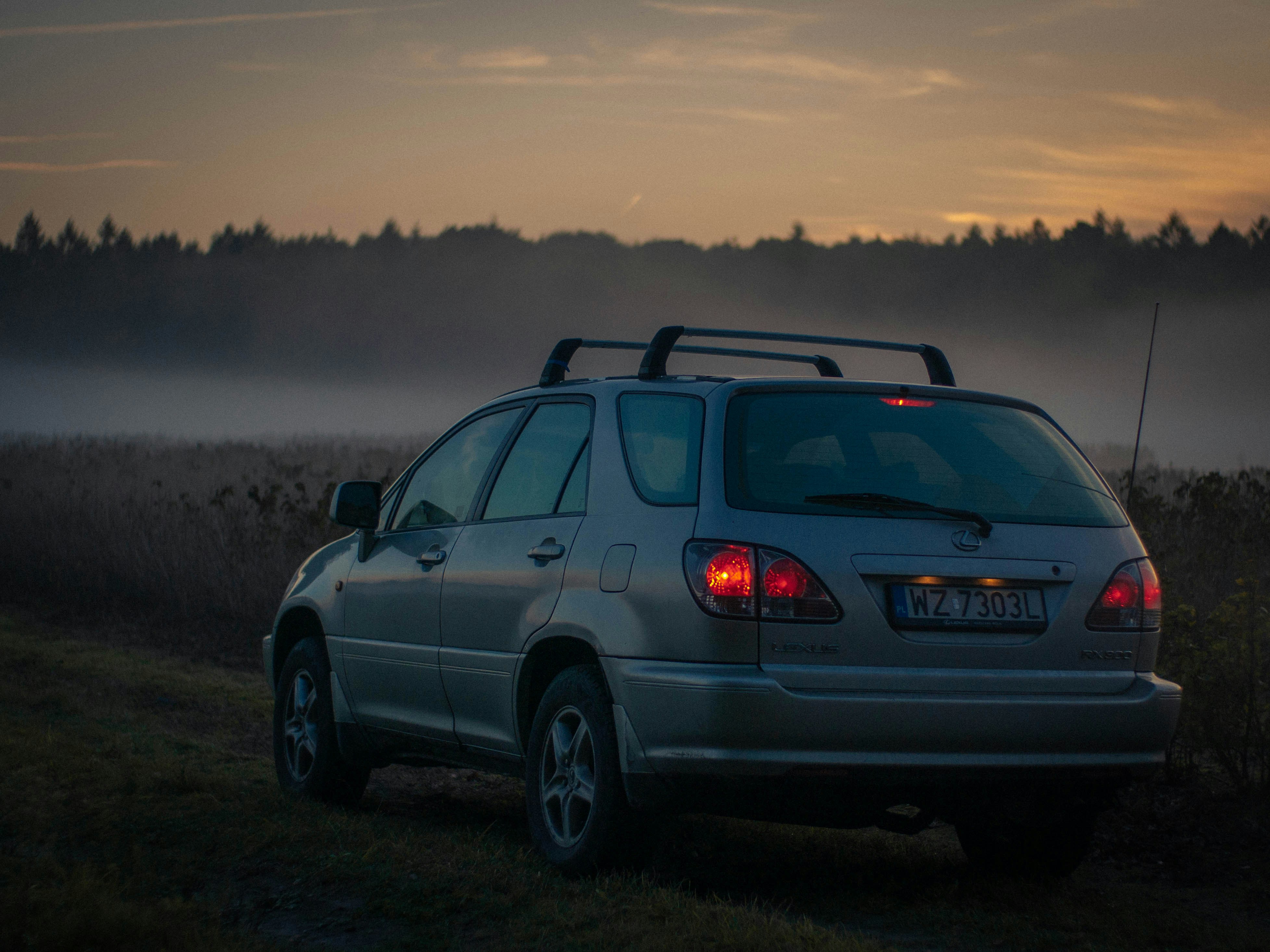ein Auto, das auf einem Feld mit Nebel im Hintergrund geparkt ist