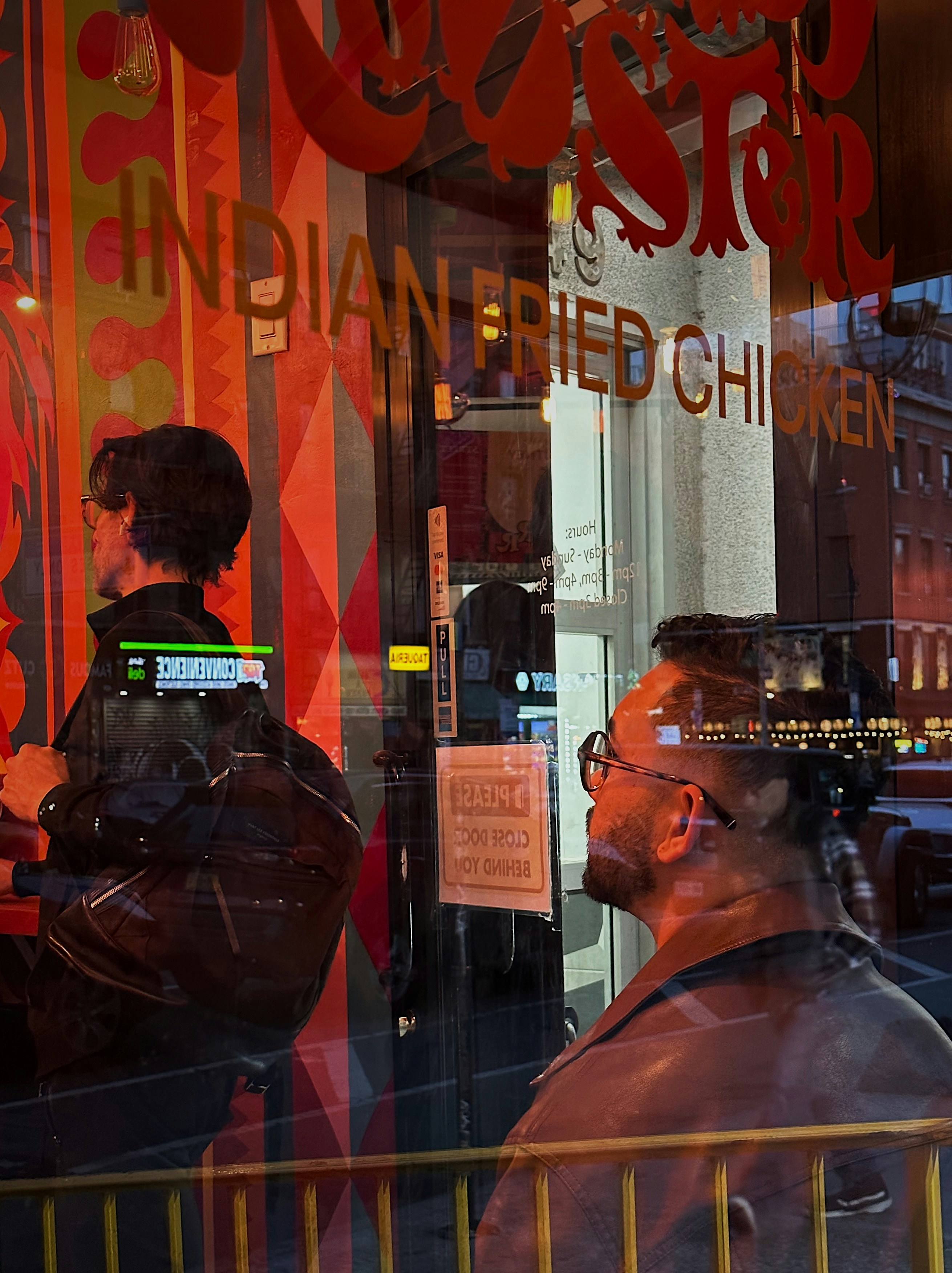 a couple of men standing in front of a store window