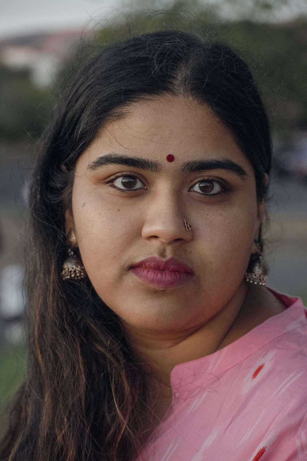 a close up of a person wearing a pink shirt