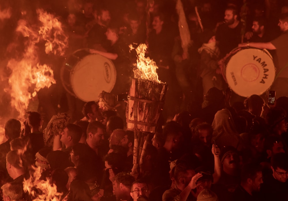 a group of people standing around a fire pit