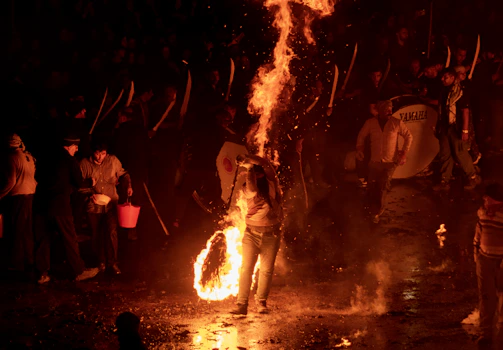 A lively gathering around a bonfire with instruments nearby.