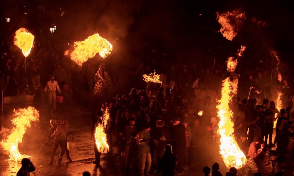 a group of people standing around a fire pit