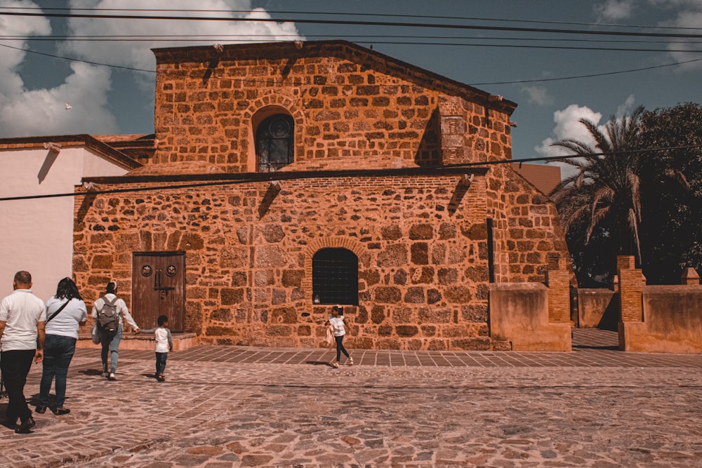 a group of people walking down a cobblestone street