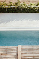 A landscaped pool area featuring neat paver installation and decorative pebbles.