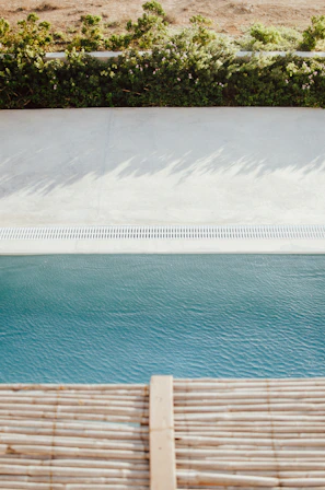 A landscaped pool area featuring neat paver installation and decorative pebbles.