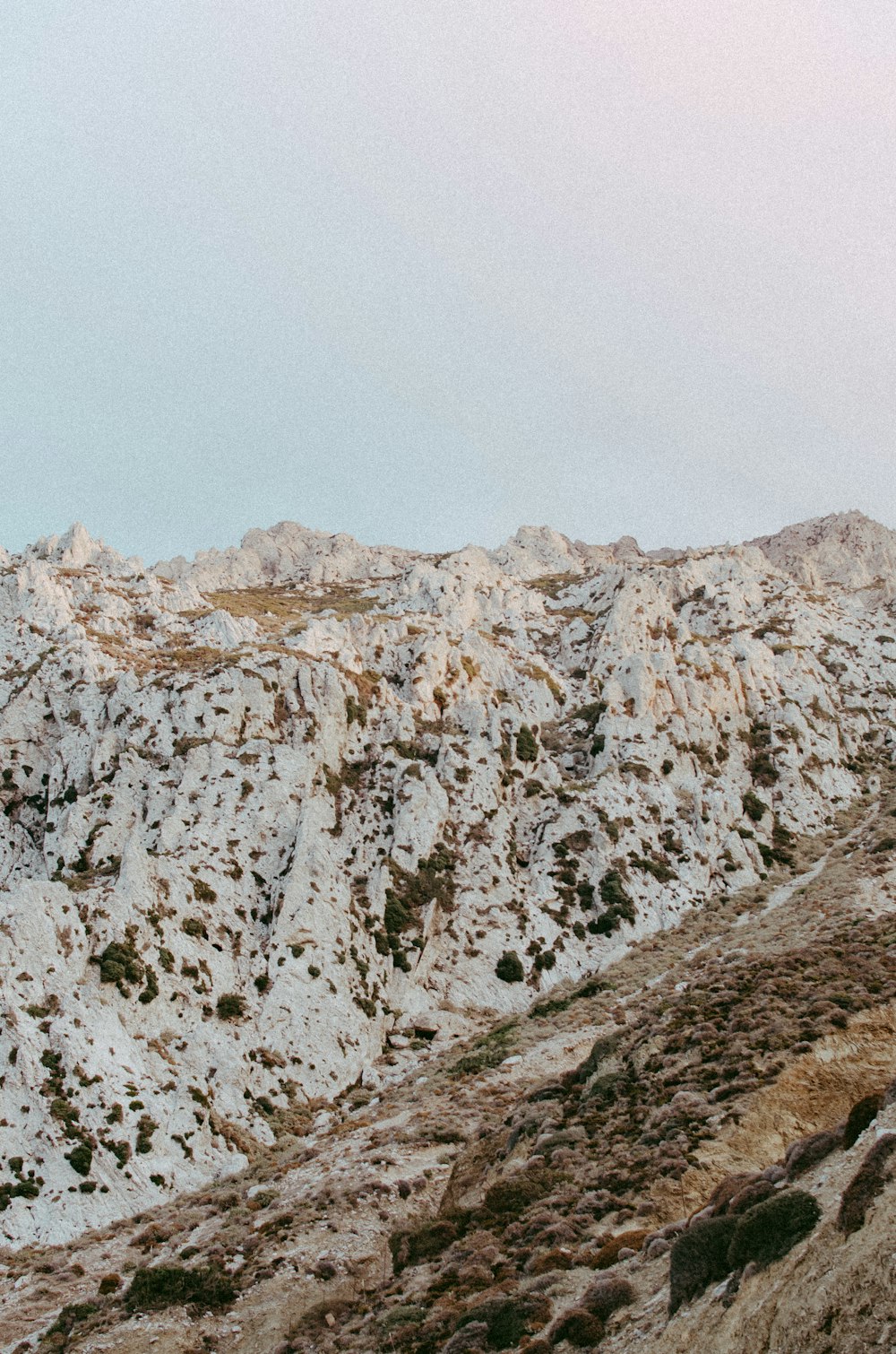 a mountain covered in snow with a sky background