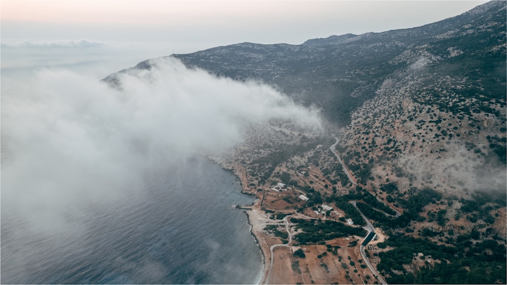 an aerial view of a mountain with low lying clouds