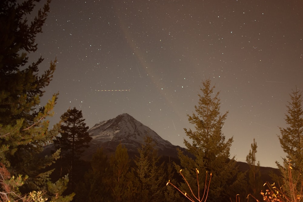the night sky with a mountain in the background