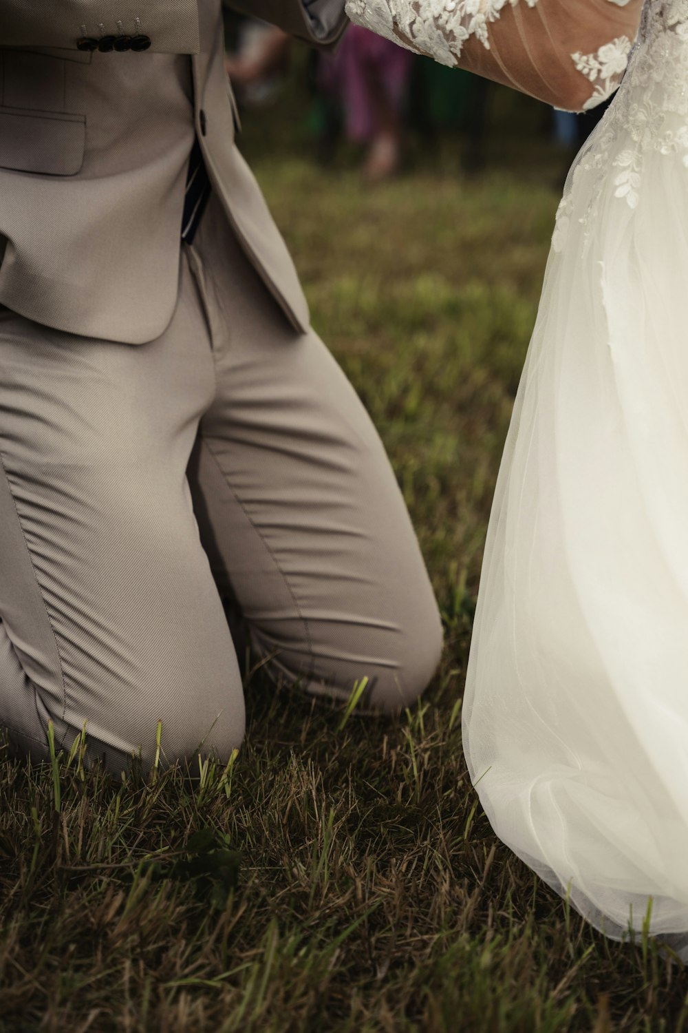 a bride and groom holding hands in the grass