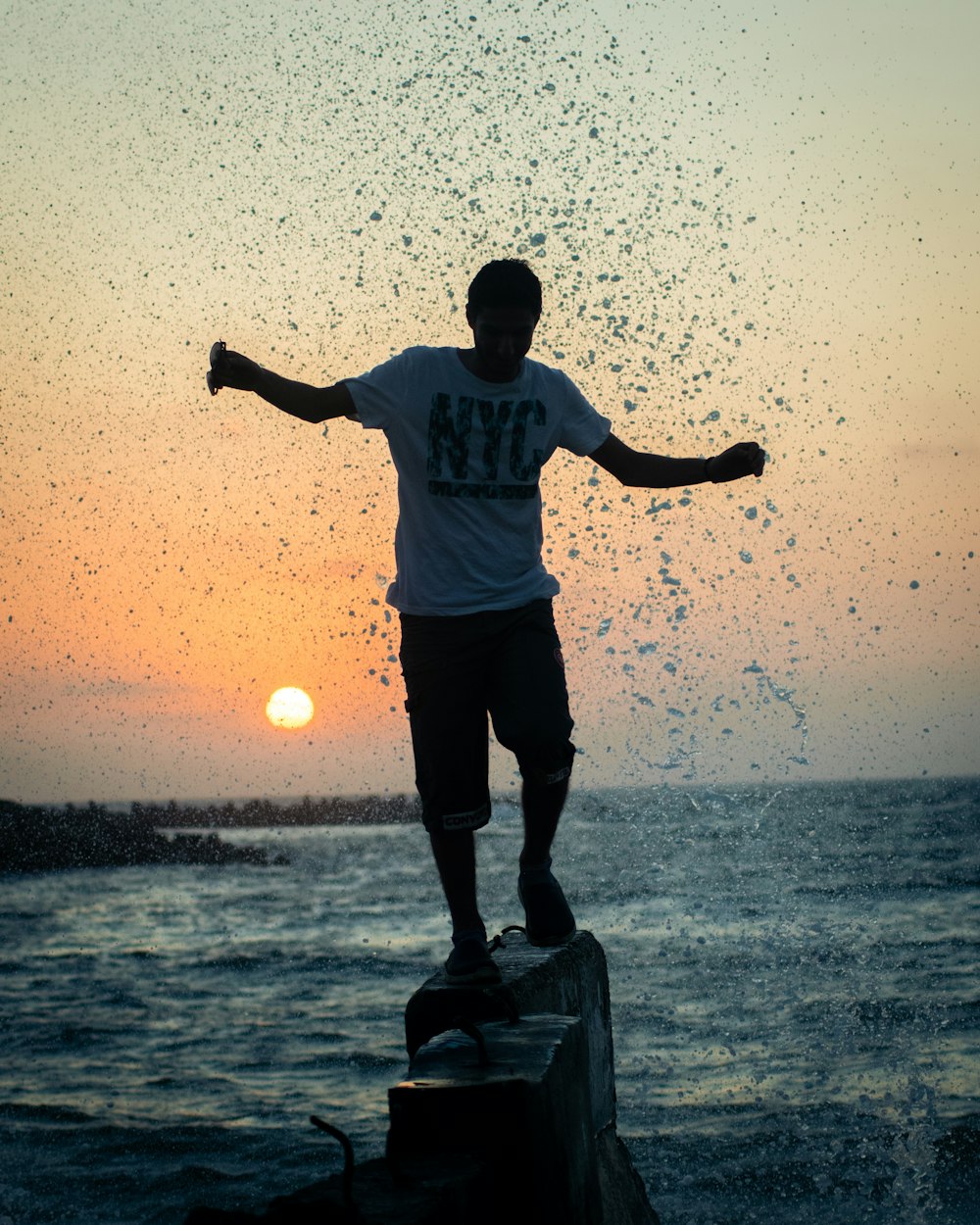 a man standing on top of a pier next to the ocean