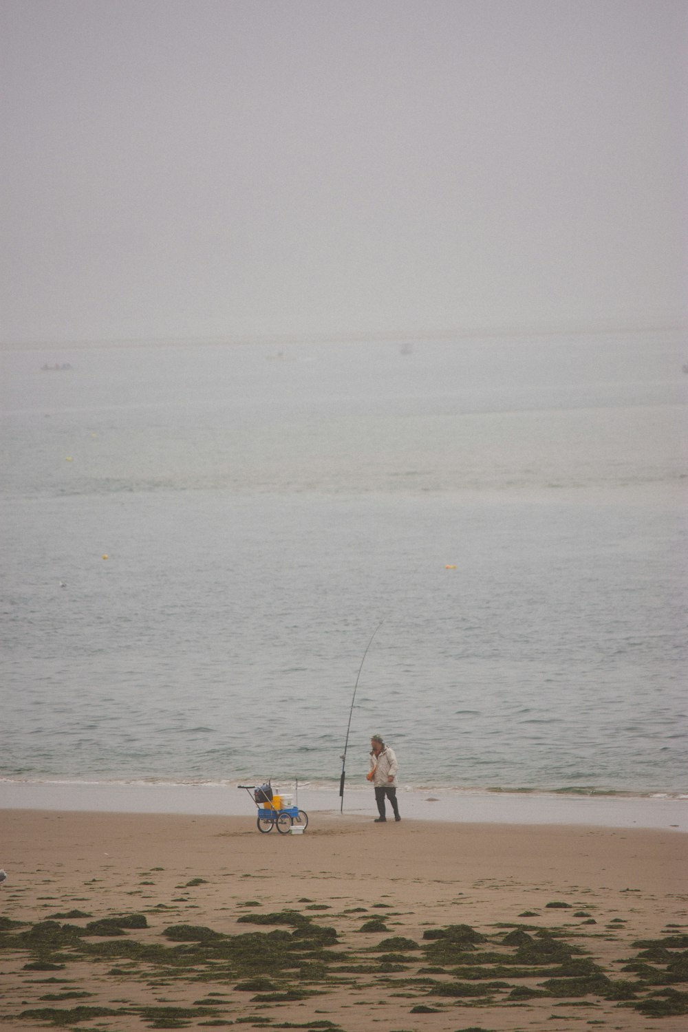 Ein Mann steht auf einem Sandstrand neben dem Meer
