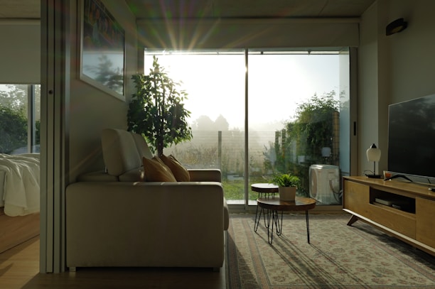 A serene living room showcasing warm beige tones, sleek furniture, and soft natural light.