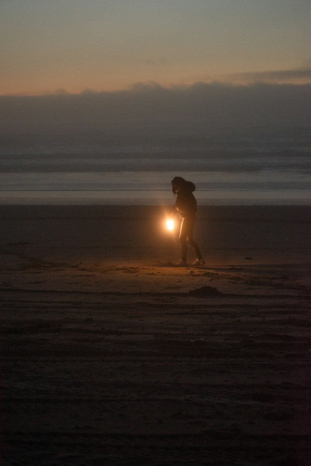 una persona en una playa con una linterna