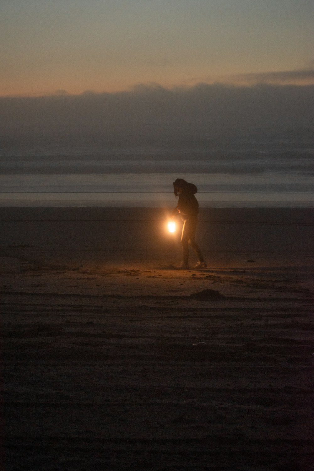 a person on a beach with a flashlight