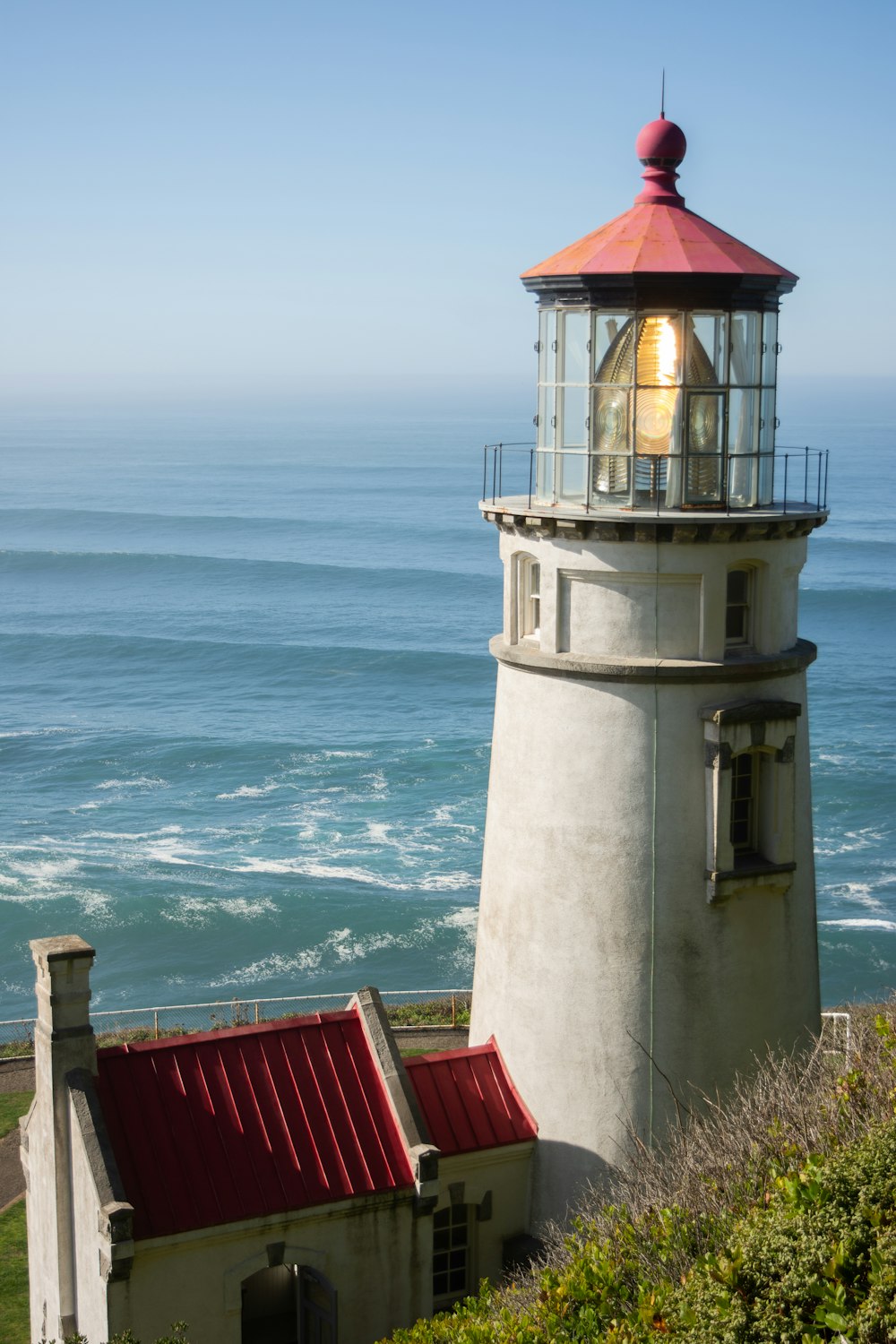 a light house sitting on top of a hill next to the ocean