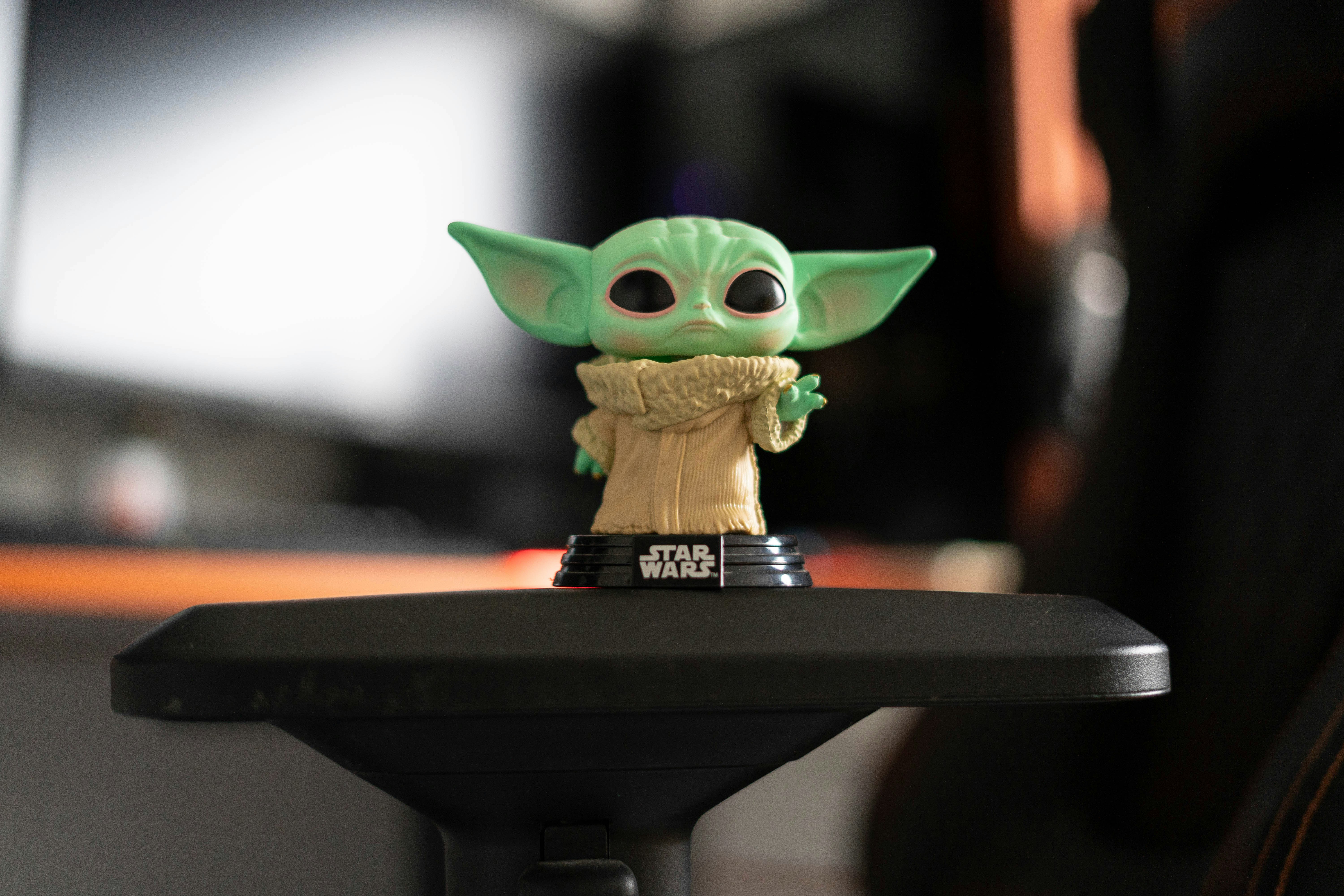 a baby yoda toy sitting on top of a desk