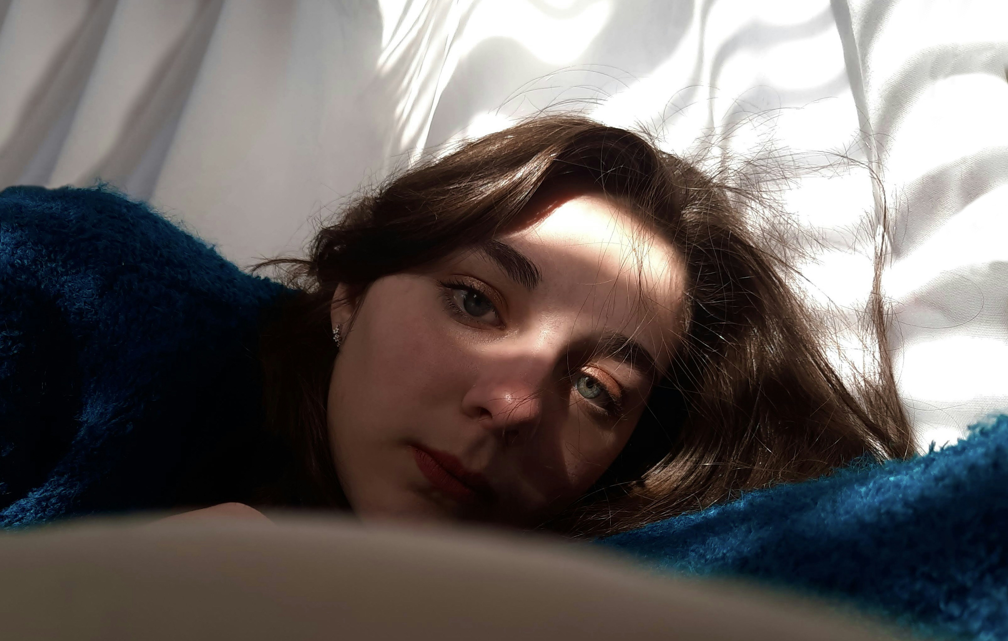 Woman under blanket showing exhaustion