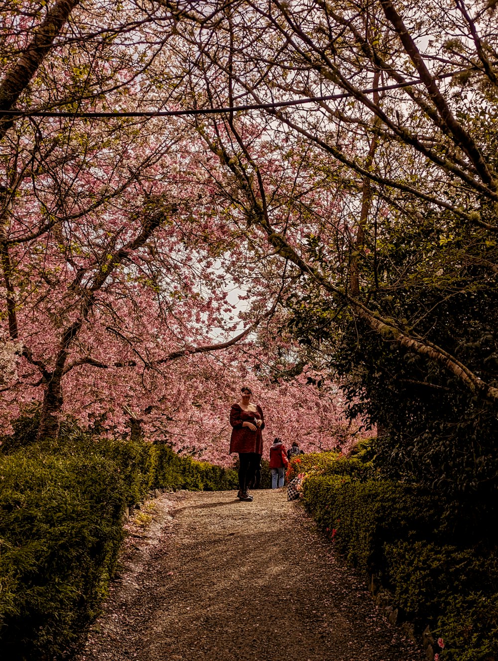 a couple of people walking down a dirt road