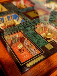 A detailed section of a Clue board game, focusing on the Study room, with rich illustrations showing bookshelves, a desk, and a decorative carpet. The game board features intricate designs and labeled rooms.