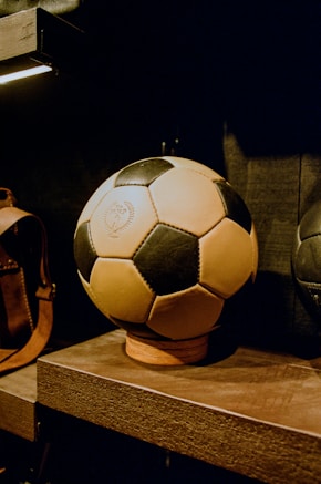 a soccer ball sitting on top of a wooden shelf