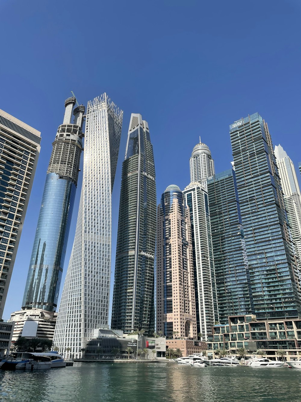 a group of tall buildings next to a body of water