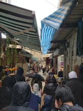 Colorful indoor market bustling with visitors on a rainy day.