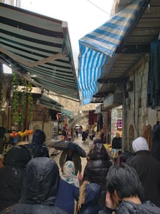 Colorful indoor market bustling with visitors on a rainy day.