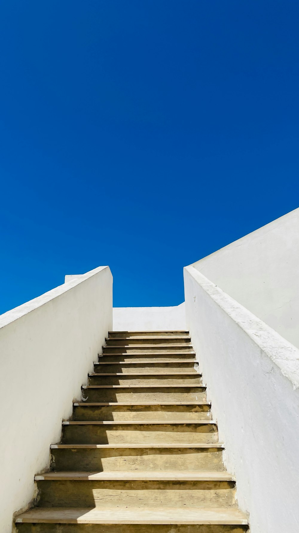 a set of stairs leading up to a blue sky