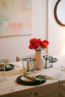 A modern dining table set with neutral-toned placemats, simple ceramic plates, and a delicate centerpiece.
