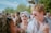 A diverse group of people smiling and wearing trendy casual clothing outdoors.