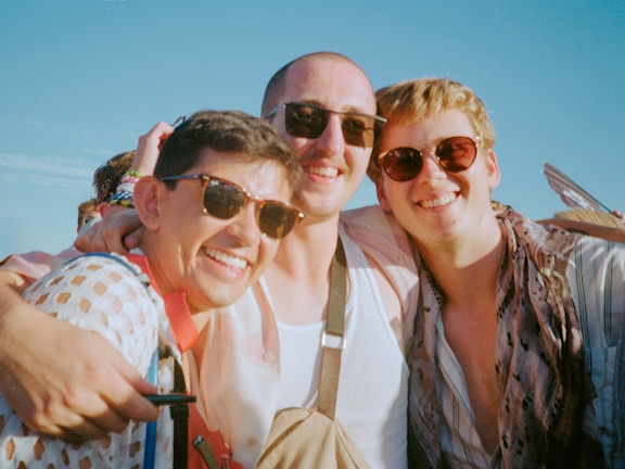 Group photo of all three team members standing together outdoors, relaxed and friendly.