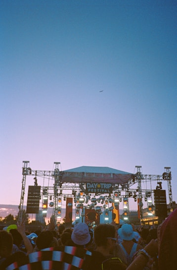 A vibrant crowd enjoying a lively outdoor music festival in Colombia at sunset.
