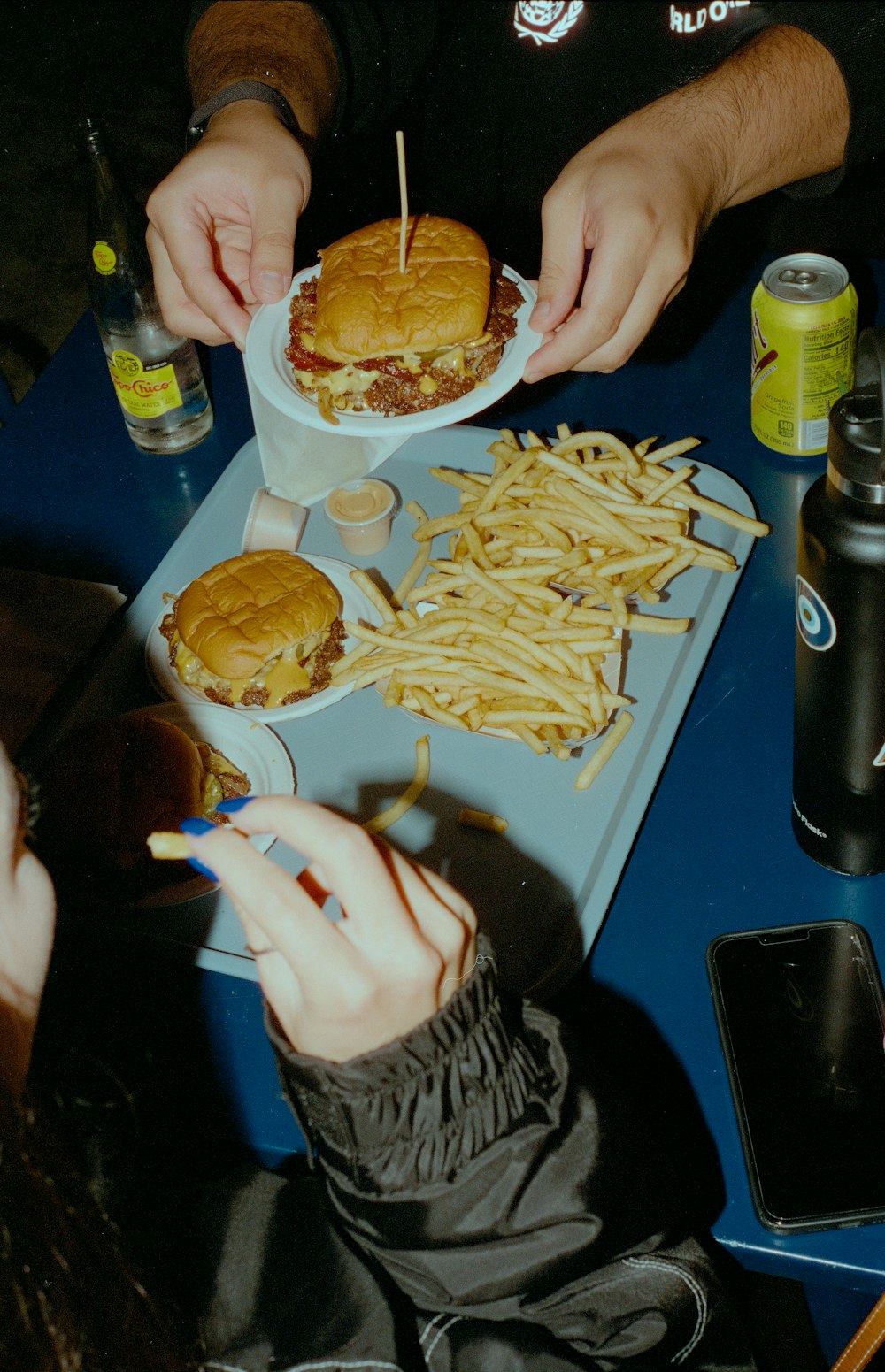 a man is eating a hamburger and french fries