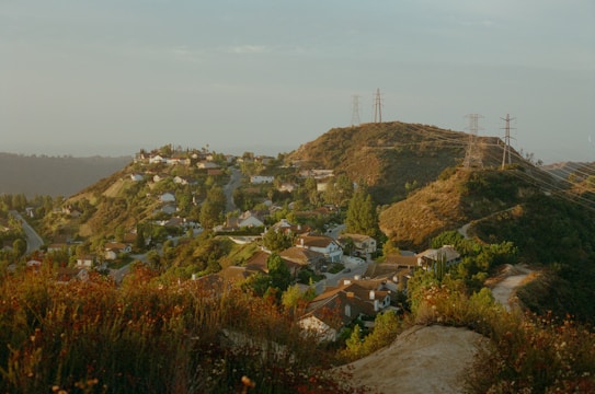 Scenic hillside residential community with winding paths and panoramic mountain views under a clear sky.