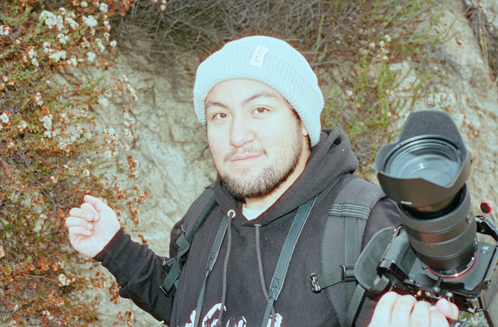 a man holding a camera and a tripod