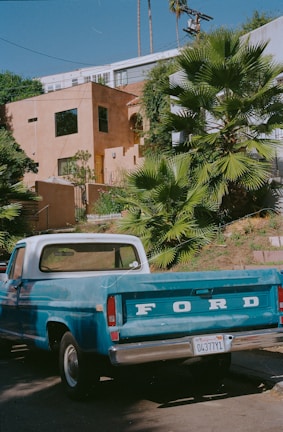A Frank Dumpster truck parked at a sunny residential driveway in Palm Springs.