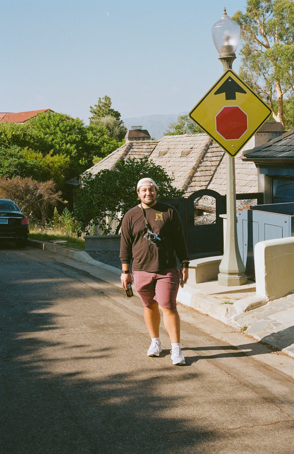 a woman walking down a street next to a stop sign