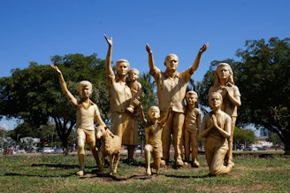 a group of statues of children and dogs in a park