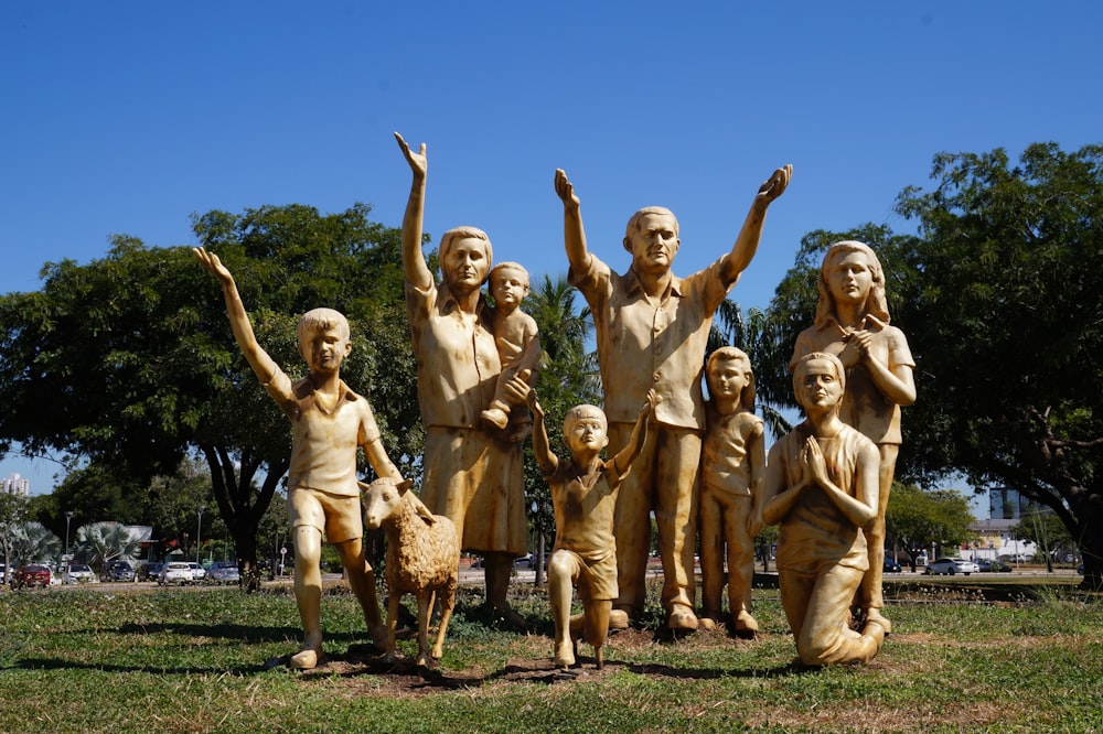 a group of statues of children and dogs in a park