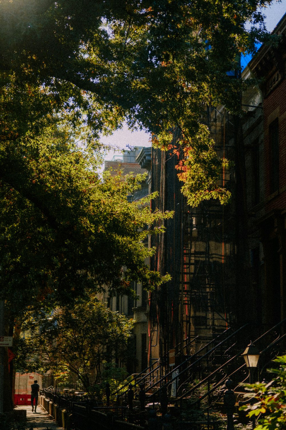 a man walking down a street next to tall buildings