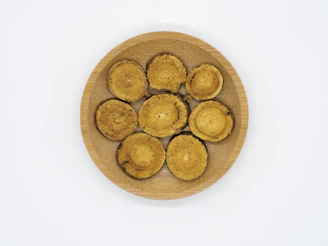 Close-up of medicinal mushrooms arranged with ritual objects on a wooden table.