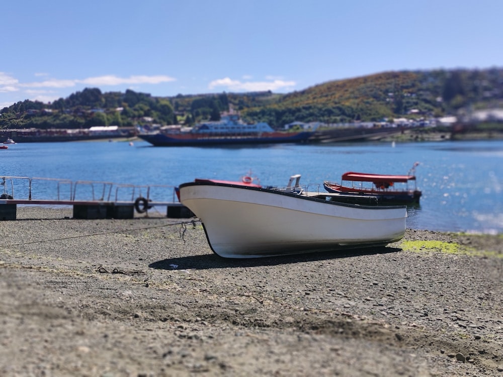 a small boat sitting on the shore of a lake