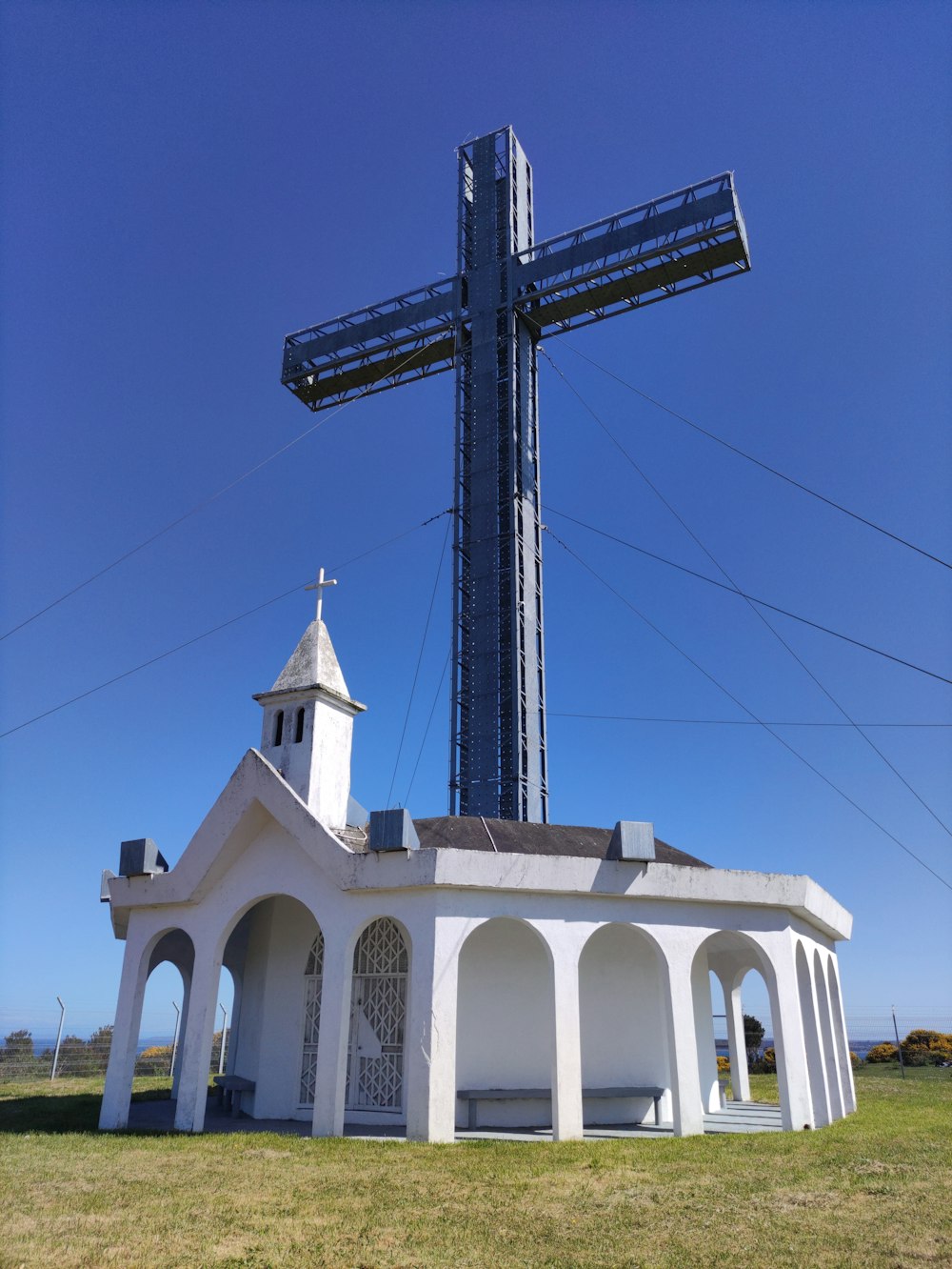 a large cross on top of a white building