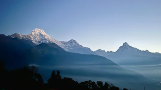 A serene Himalayan landscape with mountain silhouettes under a clear sky, evoking nine7seven’s origin.