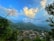 View of a vibrant Cameroonian village surrounded by green hills and clear blue sky.