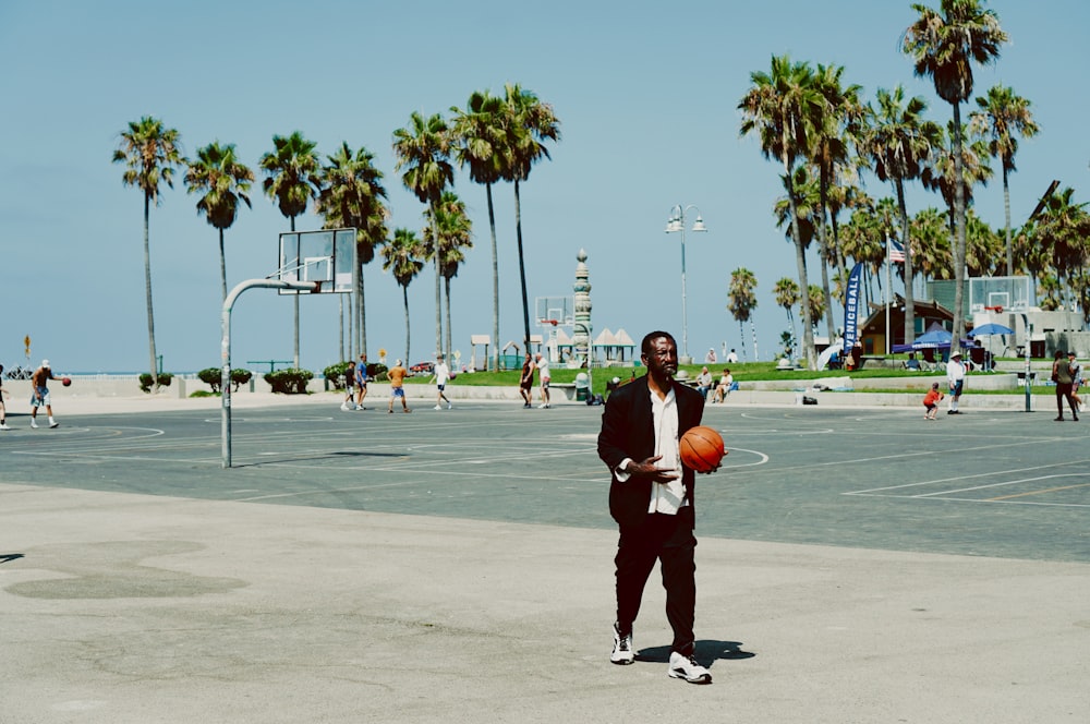 a man holding a basketball standing on a basketball court