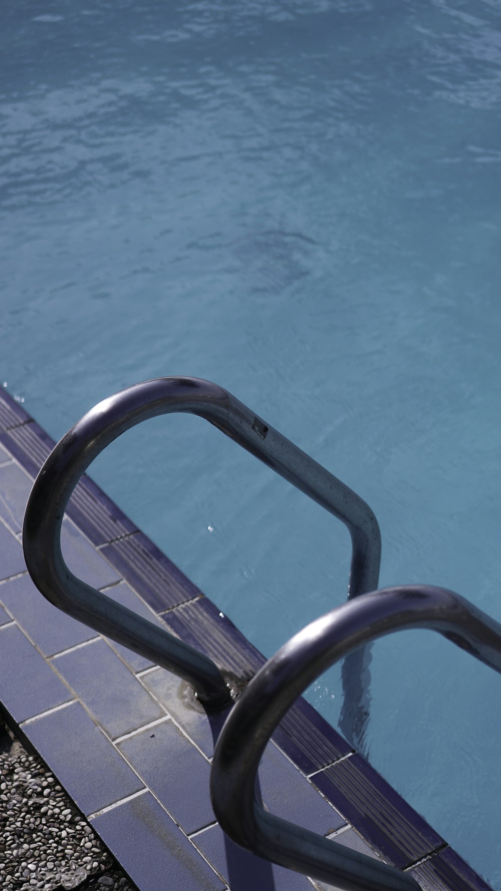 a swimming pool with a metal hand rail next to it