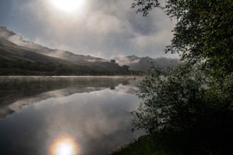 A serene view of the Lake District's rolling hills under a soft morning mist.