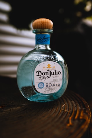 a bottle of tequila sitting on top of a wooden table