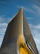 Modern architectural building with sleek lines and golden accents against a dark gradient background.